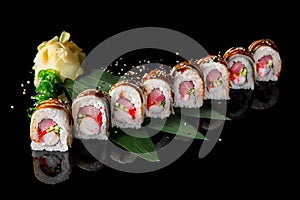 Sushi roll Maguro with tuna, shrimp, salmon, smoked eel, avocado, philadelphia cheese on black background. Sushi menu.