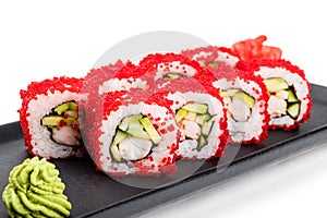 Sushi Roll - Maki Sushi with red caviar, Crab meat, cucumber, avocado on black plate over white background