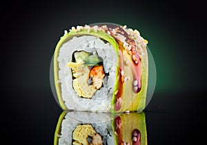 Sushi roll over black background. Sushi roll with eel, tofu, vegetables and avocado closeup