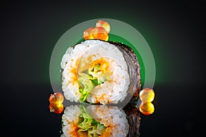 Sushi roll over black background. Sushi roll with tuna, vegetables, flying fish roe and caviar closeup