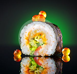 Sushi roll over black background. Sushi roll with tuna, vegetables, flying fish roe and caviar closeup