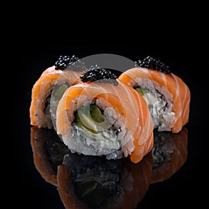 Sushi roll Philadelphia with salmon, smoked eel, avocado, cream cheese on black background. Japanese food.