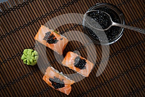 Sushi roll Philadelphia with salmon, smoked eel, avocado, cream cheese on black background. Japanese food.