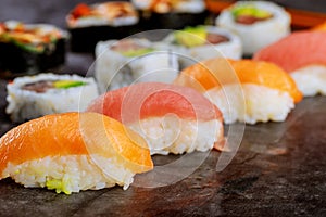Sushi roll with raw salmon on black background. Japanese food