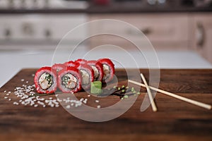 Sushi roll with salmon, avocado, cucumber and red caviar.