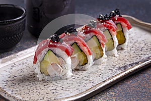 Sushi roll with salmon, cucumber and red caviar