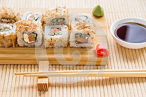 Sushi roll with salmon, cucumber and tuna skin on a wooden board