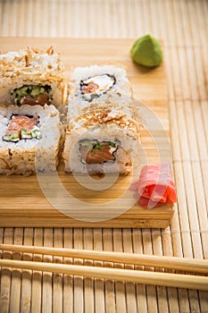 Sushi roll with salmon, cucumber and tuna skin on a wooden board