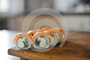 Sushi roll with salmon, cucumber on wooden board