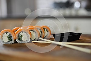 Sushi roll with salmon, cucumber on wooden board