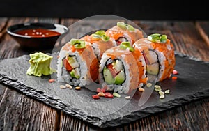 Sushi roll with salmon, smoked eel, avocado, cream cheese on a black background. Sushi menu. Japanese food.