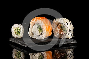 Sushi roll set with salmon, smoked eel, cucumber, cream cheese on a graphite stand