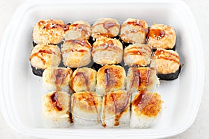 Sushi roll set in a white box. Hot baked rolls.
