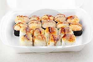 Sushi roll set in a white box. Hot baked rolls. Traditional Japanese food. Selective focus.