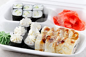 Sushi roll set in a white box. A lot of different sushi with wasabi and ginger.