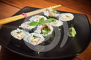 Sushi roll with tuna and cucumber on black plate