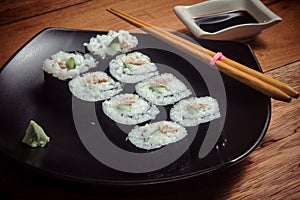 Sushi roll with tuna and cucumber on black plate