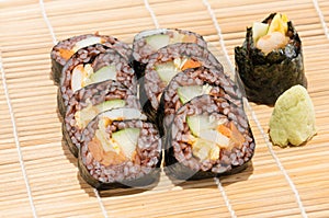 Sushi roll with vegetable and coast rice inside beside wasabi