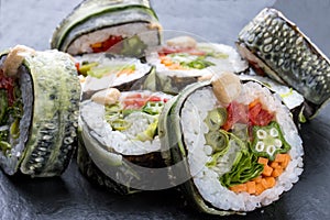 Sushi roll with vegetables on black background. Vegetarian dish