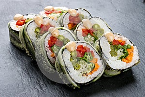 Sushi roll with vegetables on black background. Vegetarian dish