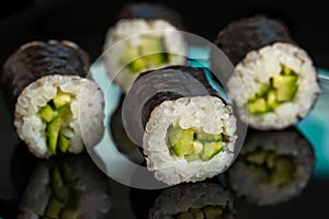 Sushi rolls with avacado on a black background. Sushi menu. Japanese food concept