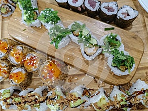 Sushi rolls with avocado and fried onion and agri-sweet sauce on wooden board