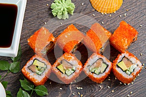 Sushi rolls and caviar on black wooden table. Japanese food.