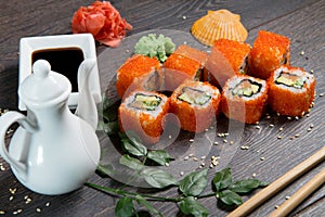 Sushi rolls and caviar on black wooden table. Japanese food.