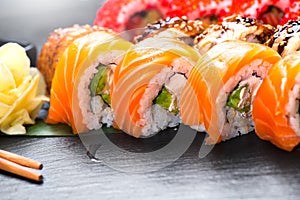 Sushi rolls closeup. Japanese food in restaurant. Roll with salmon, eel, vegetables and flying fish caviar