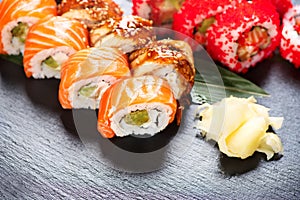 Sushi rolls closeup. Japanese food in restaurant. Roll with salmon, eel, vegetables and flying fish caviar