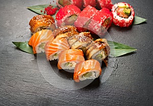 Sushi rolls closeup. Japanese food in restaurant. Roll with salmon, eel, vegetables and flying fish caviar