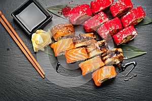 Sushi rolls closeup. Japanese food in restaurant. Roll with salmon, eel, vegetables and flying fish caviar