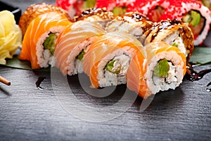 Sushi rolls closeup. Japanese food in restaurant. Roll with salmon, eel, vegetables and flying fish caviar