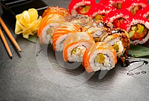 Sushi rolls closeup. Japanese food in restaurant. Roll with salmon, eel, vegetables and flying fish caviar