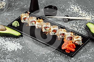 sushi rolls with cream cheese, fried salmon, tuna shavings or dried bonito, cucumber, nori. Chopsticks holding fresh