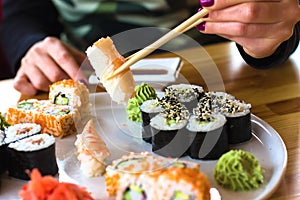 Sushi and rolls, Japanese cuisine, a girl eating sushi