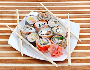 Sushi rolls on the plate with chopsticks