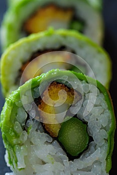 sushi rolls of red tuna, salmon, avocado and butter fish on slate dish. japanese food