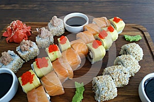 Sushi rolls set served on black stone slate on dark background