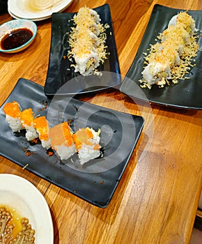 Sushi rolls on wooden table with wasabi and soy souce