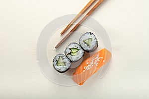 Sushi with salmon and cucumber roll with chopsticks