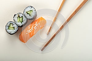 Sushi with salmon and cucumber roll with chopsticks