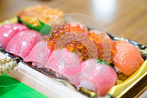 Sushi Salmon and others sushi are arranged in foam plant on the table ready to eat at Kuromon Fish Market, Osaka, Japan