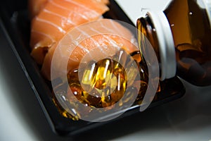 Sushi salmon served with fish oil pills poured from bottle isol