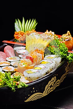 Sushi sashimi set in a wooden boat on a brown