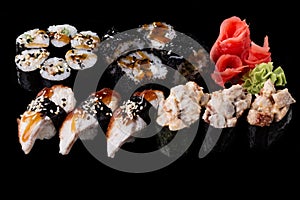 Sushi served on a black background with reflection.