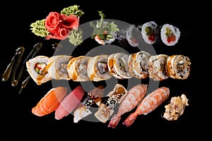 Sushi served on a black background with reflection.