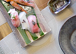 The sushi set is beautifully arranged on ceramic plate. Japanese Cuisine Buffet. Chef`s Choice: Shrimp, Tuna, Nodoguro and KINKI photo