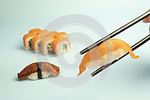 Sushi set and black chopsticks on blue background. Japanese traditional cuisine. asian food