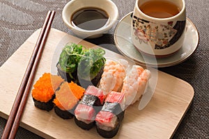 Sushi set with chop sticks and soy sauce served on wooden slate